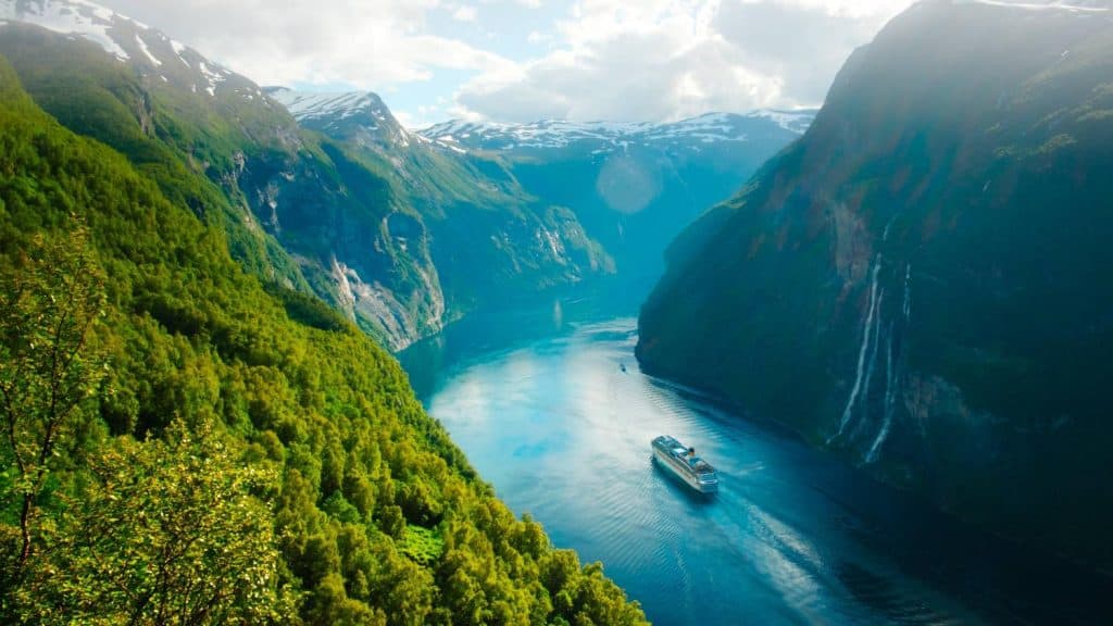 Beautiful fjord landscape with boat cruising through steep cliffs in Norway.